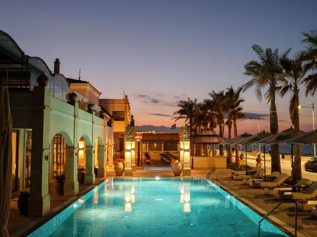 Grecotel Plaza Beach House baseins piekrastē saulrieta gaismā