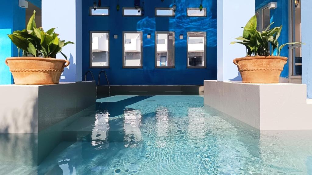 Grecotel Plaza Beach House baseins ar ziediem un saulainām sienām