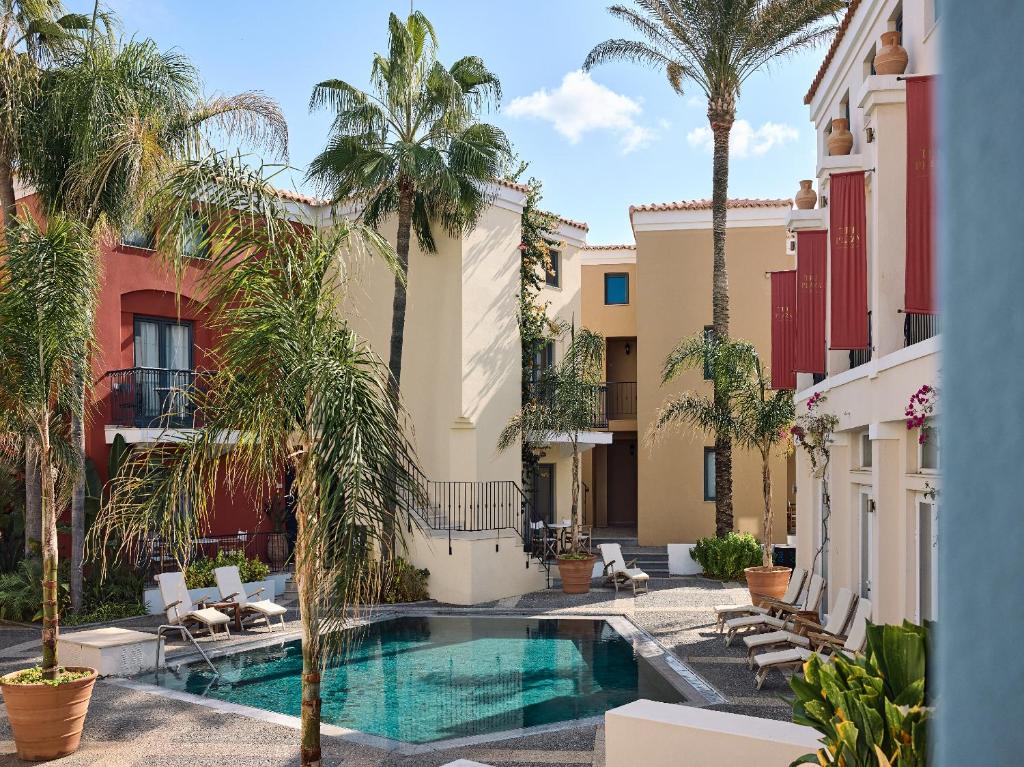 Grecotel Plaza Beach House iekšējais pagalms ar baseinu un palmām