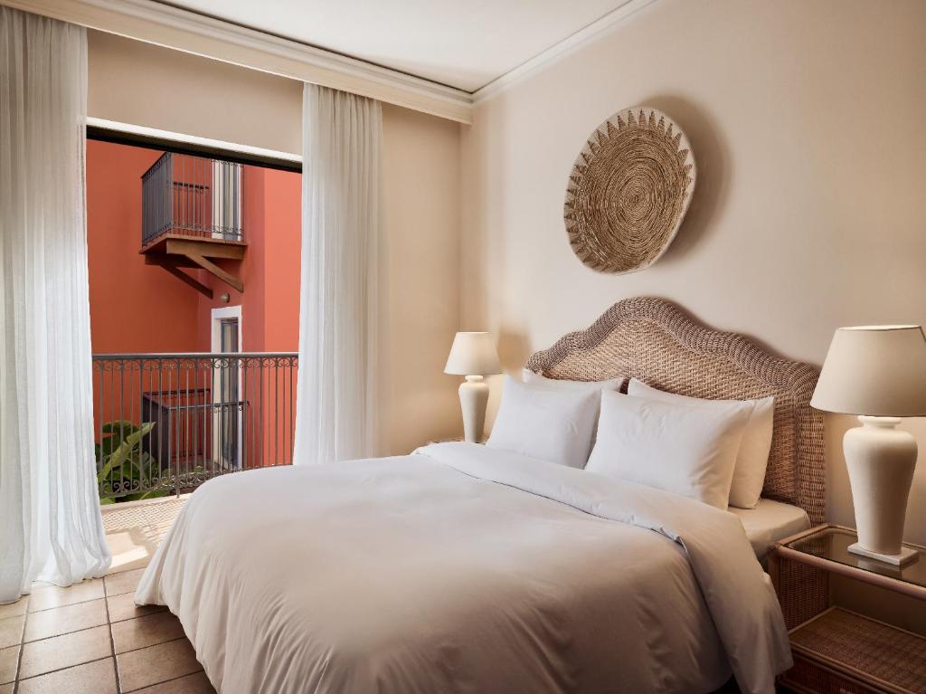 Grecotel Plaza Beach House numurs ar balkonu un mūsdienīgu interjeru.