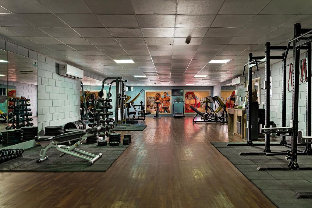 Mūsdienīgs sporta zāles interjers ar dažādiem trenažieriem un svaru komplektiem, kas veicina aktīvu dzīvesveidu. Sienas rotā krāsainas grafikas, kas motivē apmeklētājus.