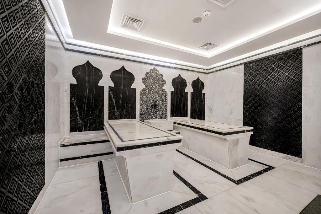 Mūsdienīga marmora telpa ar melnu un baltu dekoru, kas iekļauj elegantu arhitektūru un stilīgas līnijas. Ideāli piemērota relaksācijai un atpūtai.