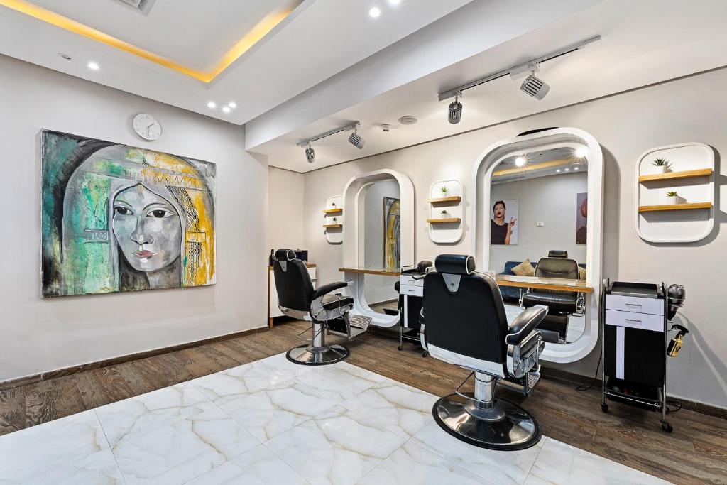 Moderns frizieru salons ar stilīgu interjeru, kas ietver māksliniecisku gleznu un funkcionālas frizieru krēslus. Eleganta atmosfēra, kas aicina uz relaksāciju un skaistumkopšanu.