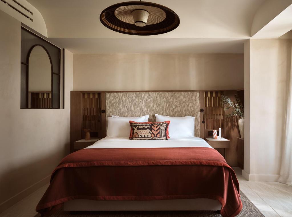 Mūsdienīga guļamistaba ar ērtu gultu, dekoratīviem spilveniem un siltām krāsām, piedāvā relaksējošu atmosfēru. Interjera dizains apvieno eleganci un mūsdienīgumu.