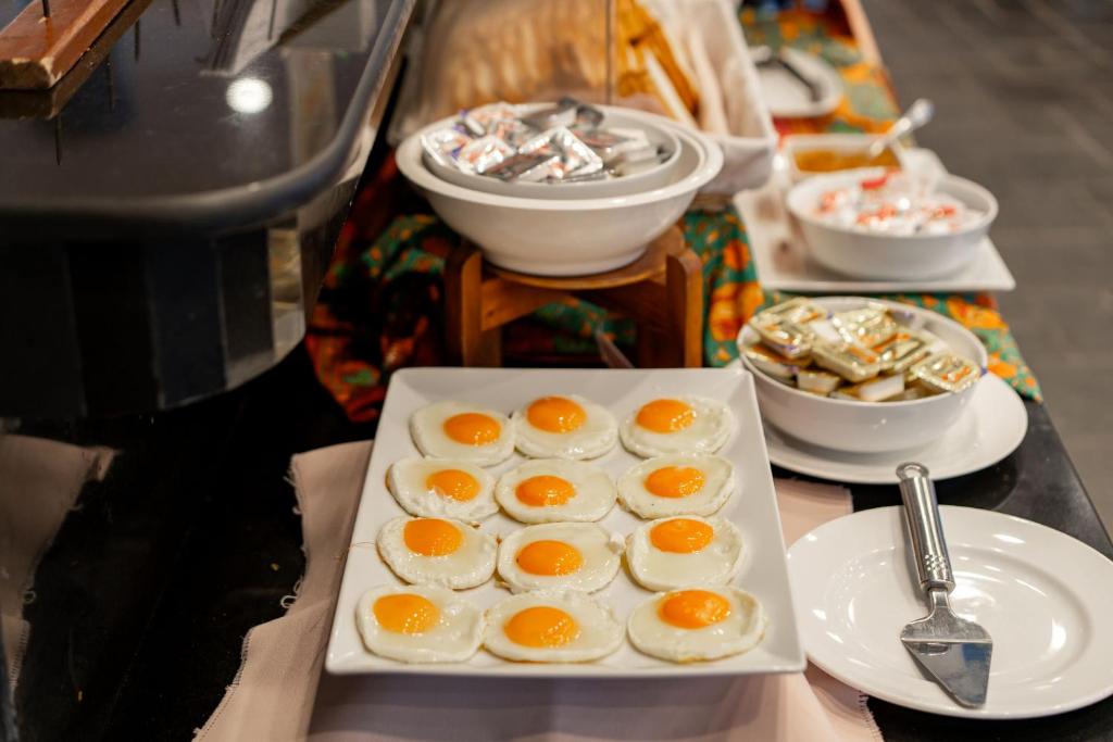 Broka ar ceptām olām uz galda, kur blakus redzami dažādi piedevas un saldumi.