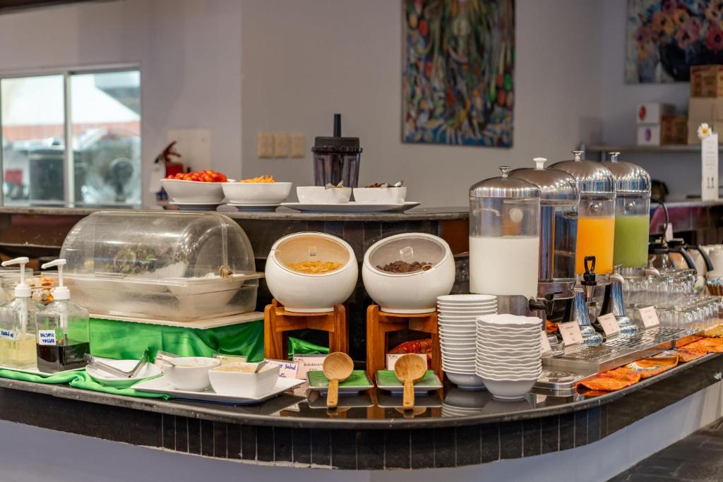 Buffet stacija ar dažādiem ēdieniem, dzērieniem un traukiem, piemēram, graudaugiem, jogurtu, augļiem un sulām. Viegli pieejamie piedāvājumi, kas piemēroti brokastīm vai vieglām uzkodām.