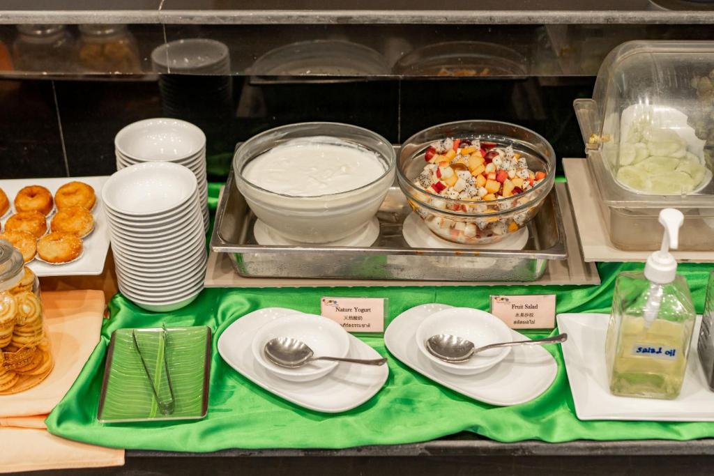 Bagātīgs bufetes galds ar jogurtu, augļu salātiem, cepumiem un saldām uzkodām. Pieejami dažādi trauki un piederumi.