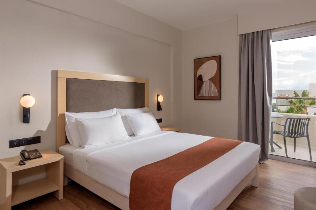 Moderns numurs Zeus Hotels Ydoria Resort ar balkonu un ērtu gultu.