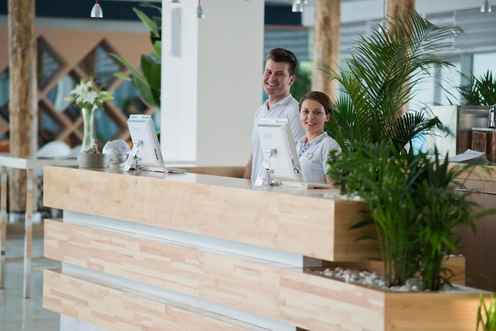 Smaidoši viesnīcas darbinieki pie Selene Beach and Spa Hotel reģistratūras.