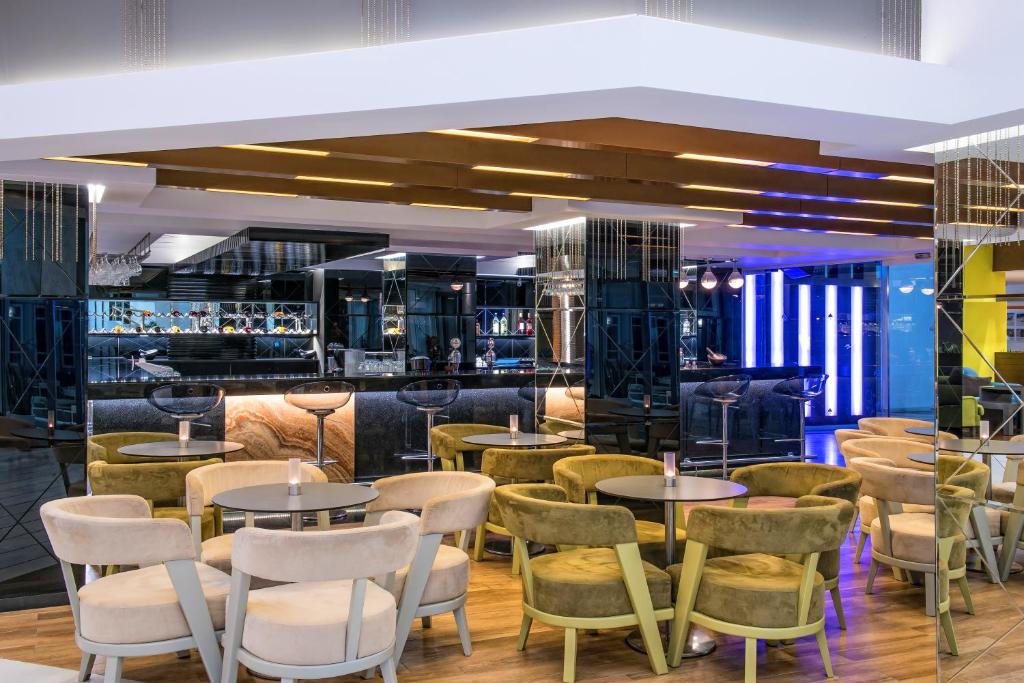 Moderns bārs Fodele Beach & Water Park Resort ar stilīgām mēbelēm un apgaismojumu.