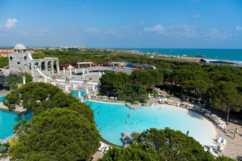 Xanadu Resort Hotel baseins ar skatu uz jūru un zaļiem kokiem.