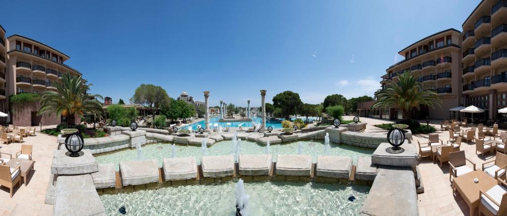 Xanadu Resort Hotel baseins un viesnīca piekrastē ar palmām un saulainu laiku.