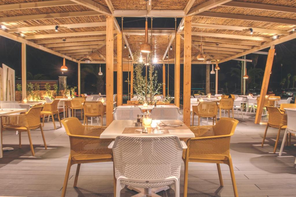 Moderns restorāns ar koka konstrukciju, dekoratīvām lampām un elegantām mēbelēm, radot patīkamu atmosfēru vakara maltītēm.