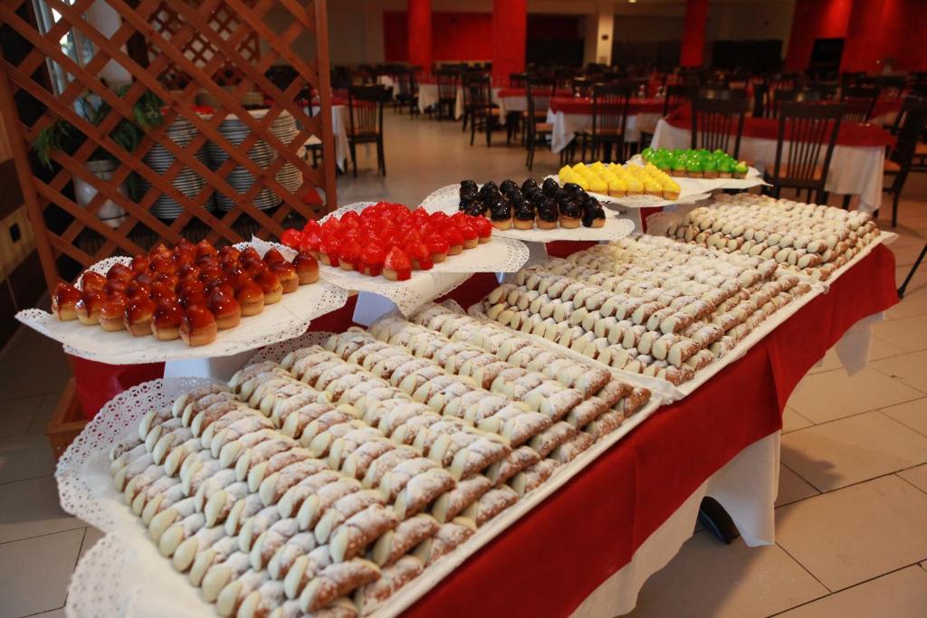 Saldumu bufete ar dažādiem desertiem, tostarp augļu želejām un krēmīgām kūkām, izkārtota uz galda restorānā.