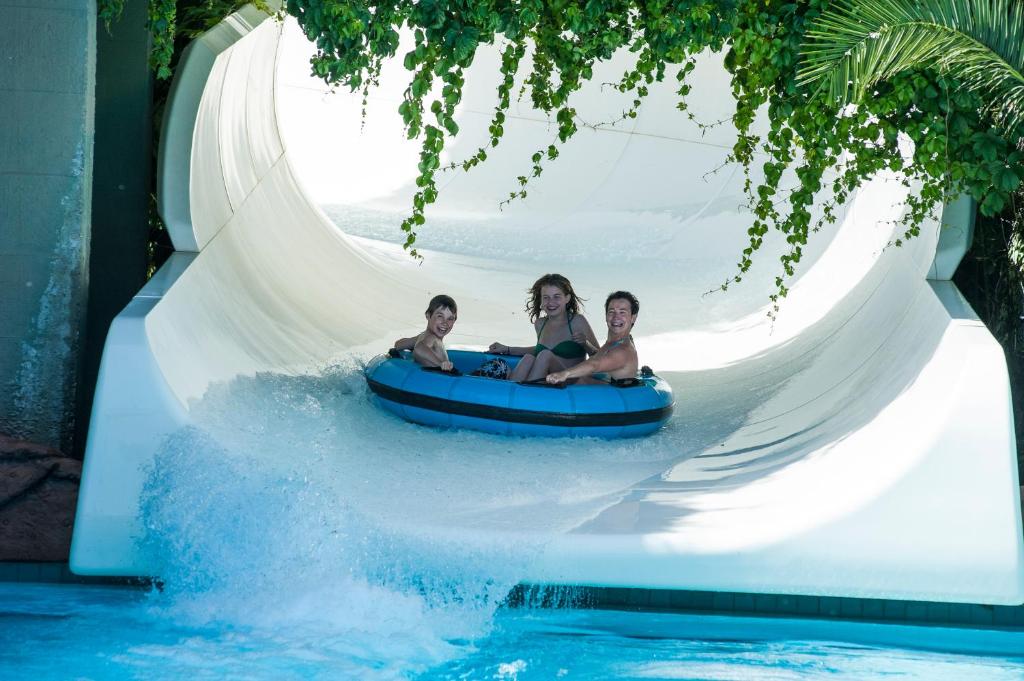 Bērni, kas priecīgi iznirst no ūdens slidkalniņa Ali Bey Club