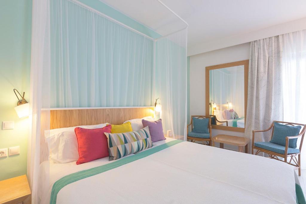 Mūsdienīgs guļamistabas interjers ar gultu, kas rotāta ar spilveniem un gaismas elementiem, kā arī spoguli un ērtām krēslām. Gaisīga un relaksējoša atmosfēra ar gaišām krāsām.