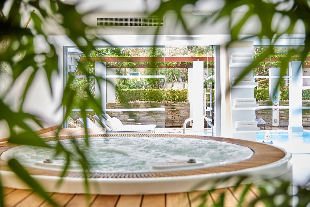 Luksusa spa telpa ar burbuļvannu un skatu uz dārzu, kas piedāvā relaksējošu atmosfēru. Ideāla vieta atpūtai un labsajūtai.