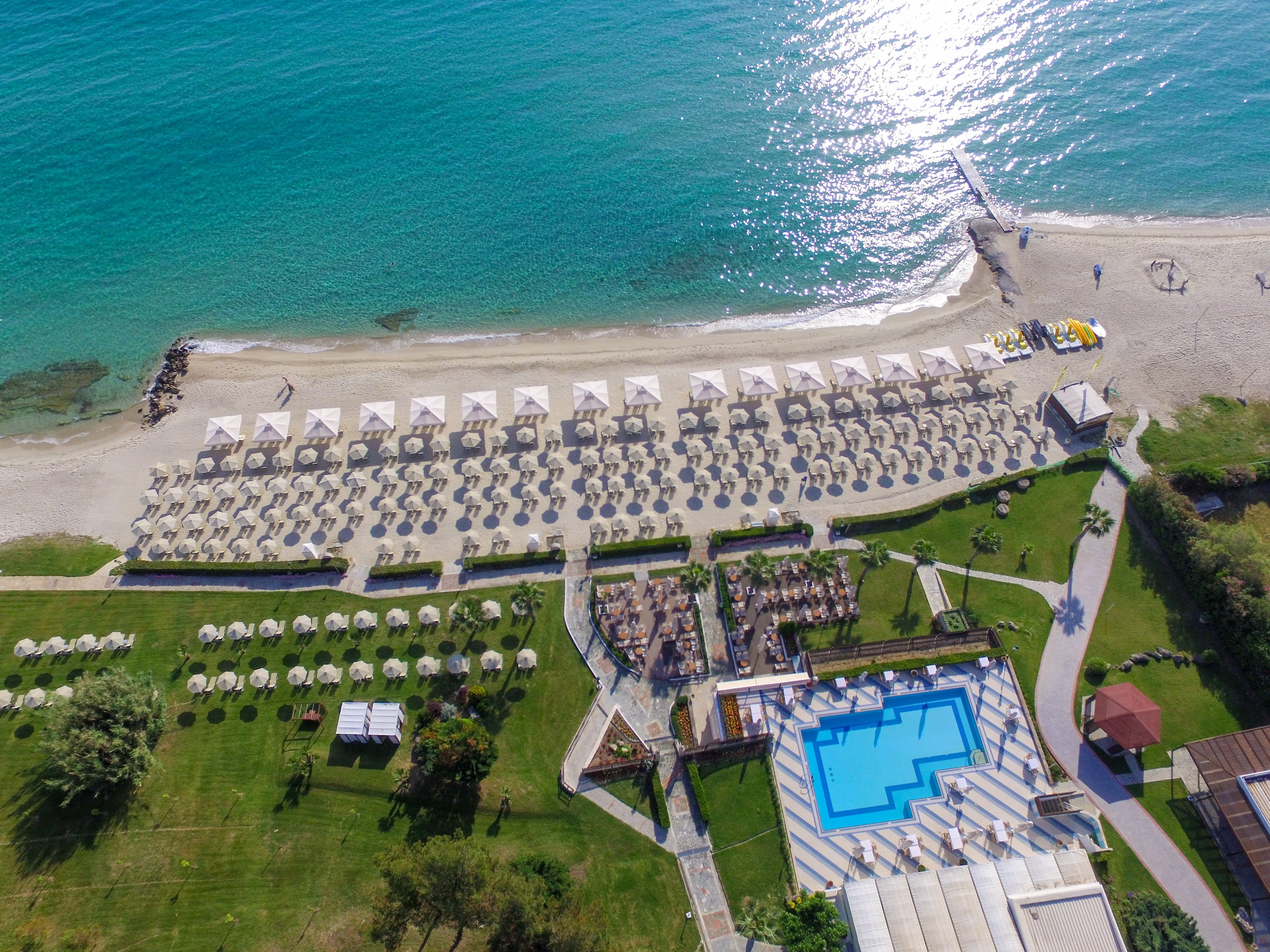 Pludmales kūrorts ar saulessargiem, baseinu un skatu uz zilo jūru. Ideāla vieta atpūtai un izklaidei. panoramic view with beach and pools