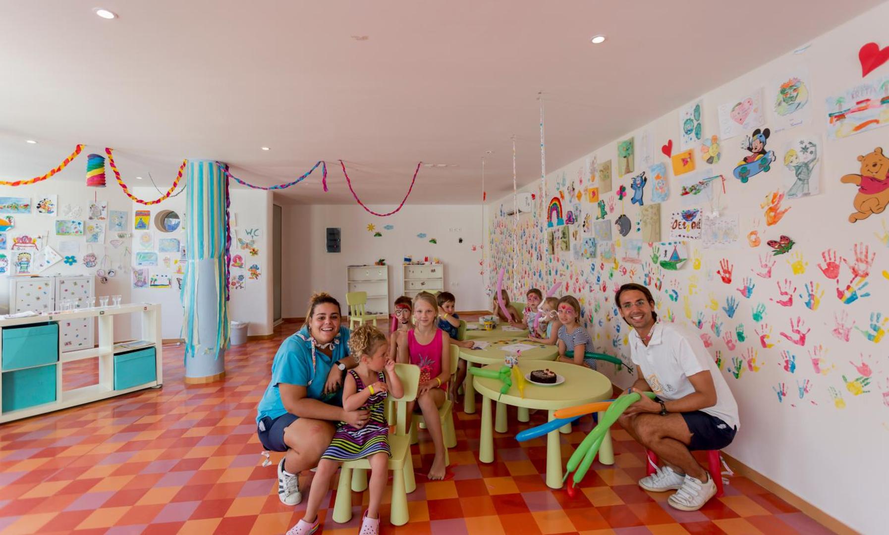 Dessole Malia Beach bērnu klubs ar krāsainām sienām, zīmējumiem un animatoriem, kas strādā ar bērniem iekštelpās