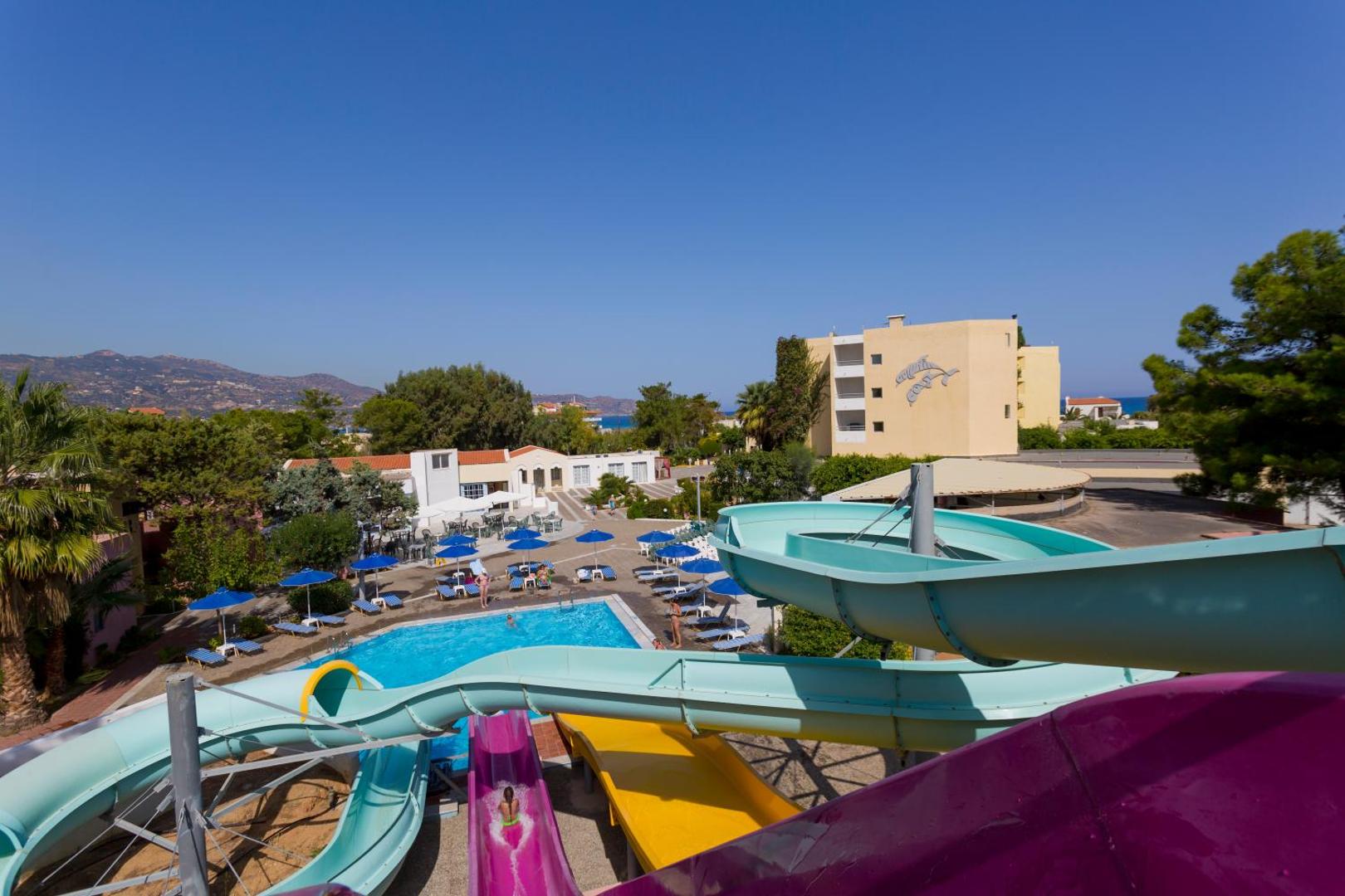 Dessole Malia Beach akvaparks ar krāsainiem ūdens slidkalniņiem — skats no augšas uz baseinu zonu un viesnīcas teritoriju Malijā