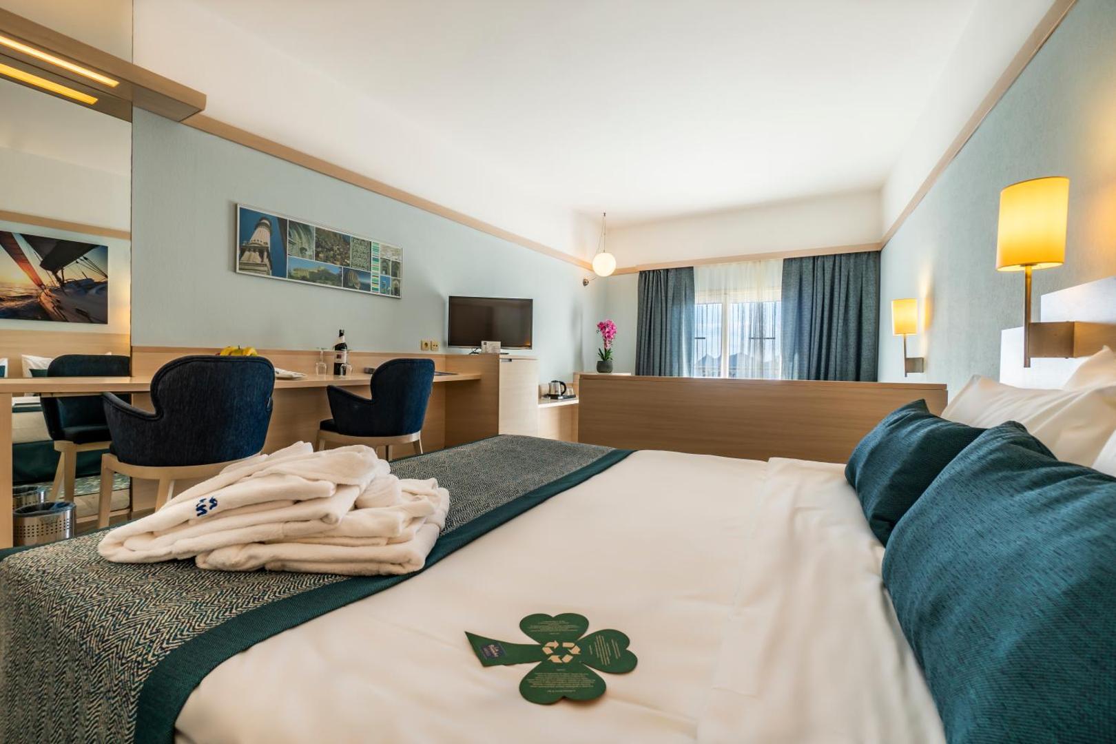 La Blanche Resort & Spa numura kopskats ar gultu priekšplānā un darba galdu fonā, gaišos toņos Bodrumā