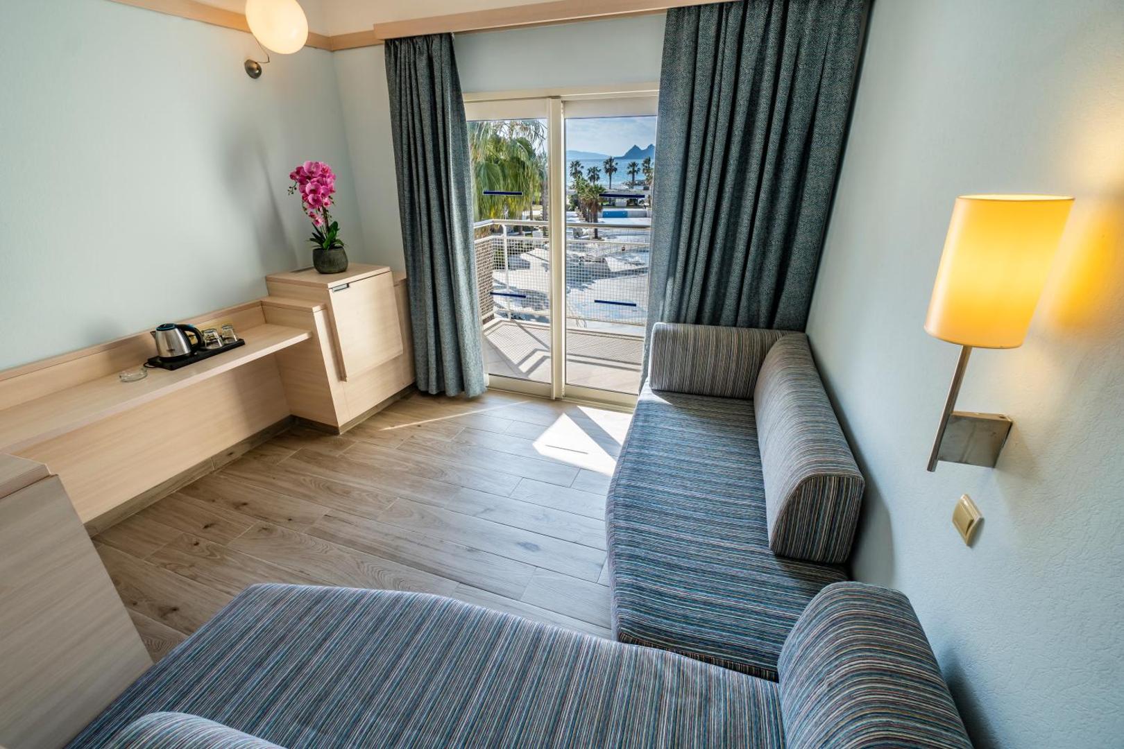 Skats no La Blanche Resort & Spa numura balkona uz viesnīcas dārzu, baseinu un Egejas jūru Bodrumas reģionā