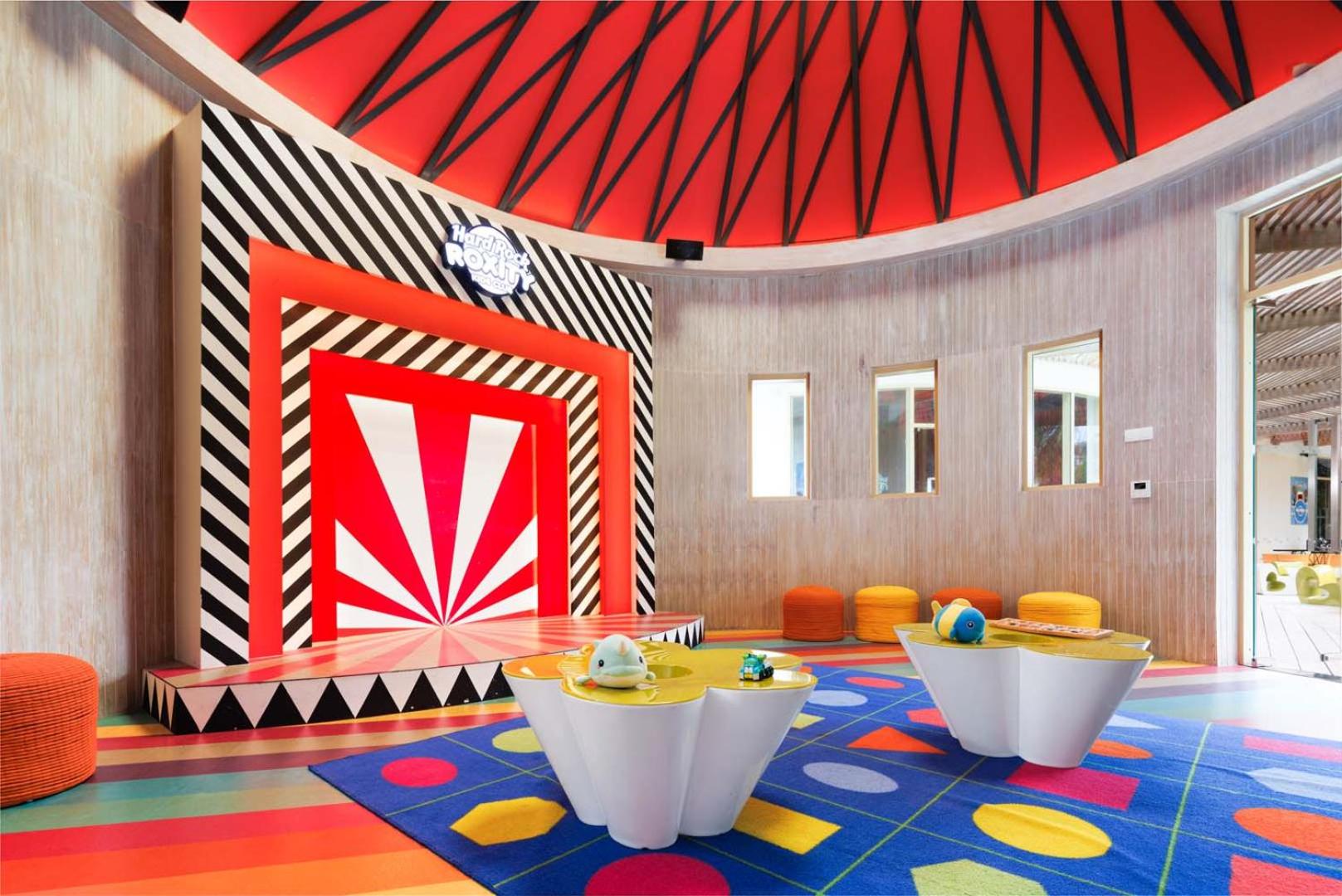 Hard Rock Roxity Kids Club iekštelpu zona ar skatuvi un mīkstajiem sēžammaisiem — vieta bērnu pasākumiem un izklaidei