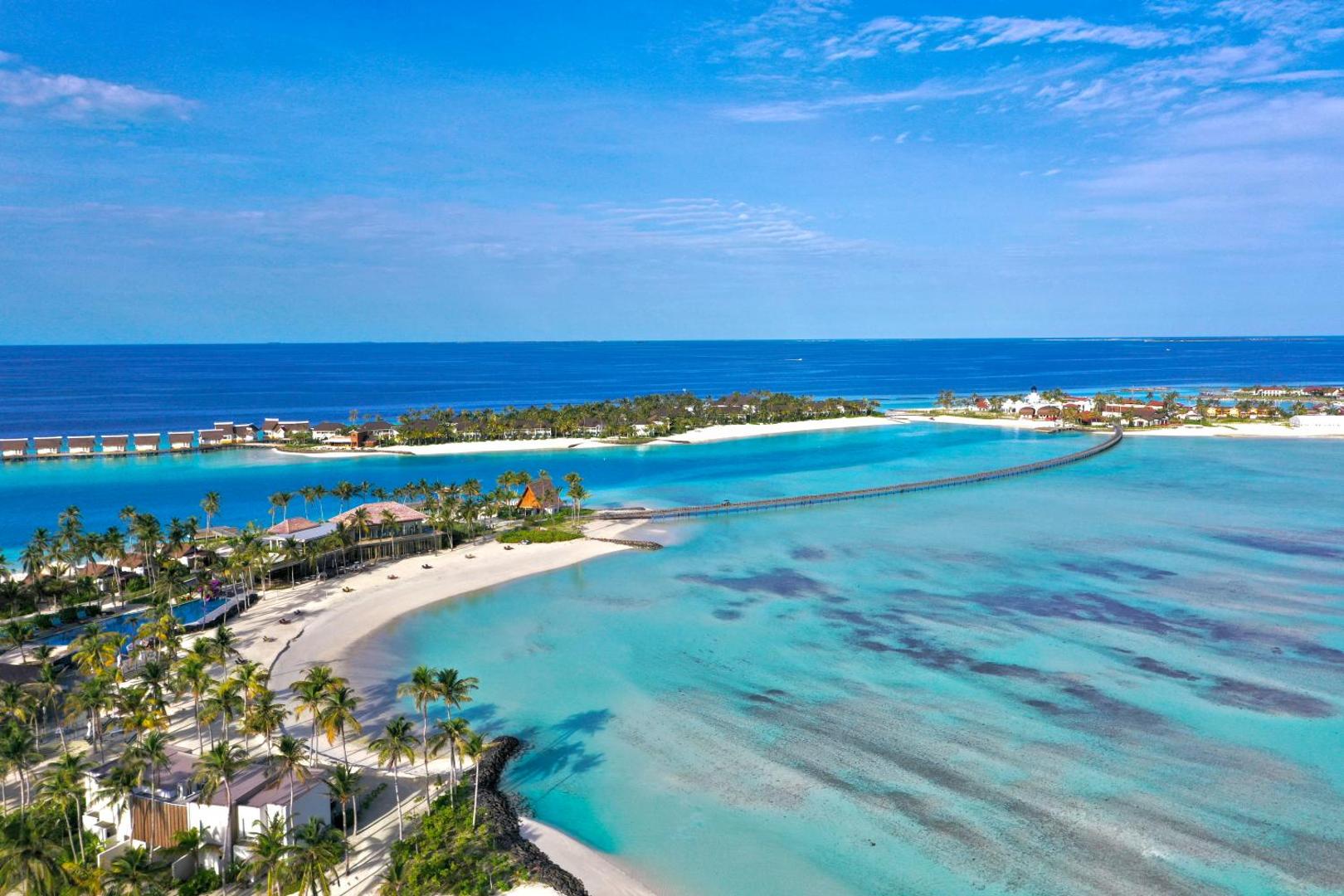Hard Rock Hotel Maldives panorāmas skats no putna lidojuma uz salu, tirkīzzilo lagūnu, tiltu un pludmales villām