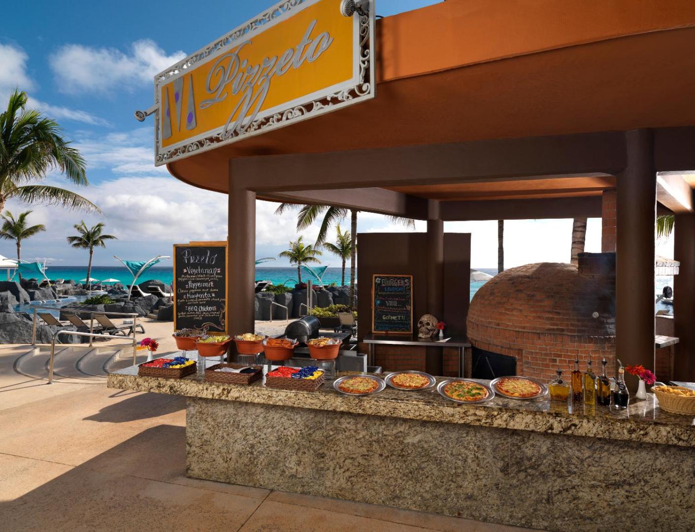 Hard Rock Hotel Cancun picērija Pizzeto pie baseina ar malkas krāsni un skatu uz tirkīzzilo jūru Kankunas piekrastē
