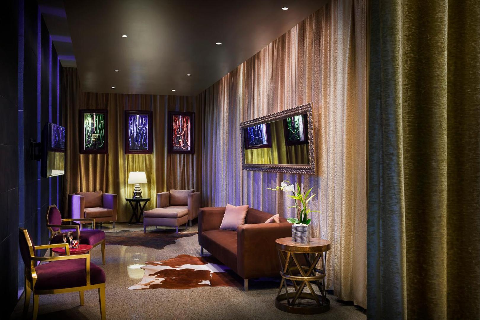 Hard Rock Hotel Cancun atpūtas zona ar mīkstajiem krēsliem, dīvānu un zelta krāsas aizkariem elegantā interjerā