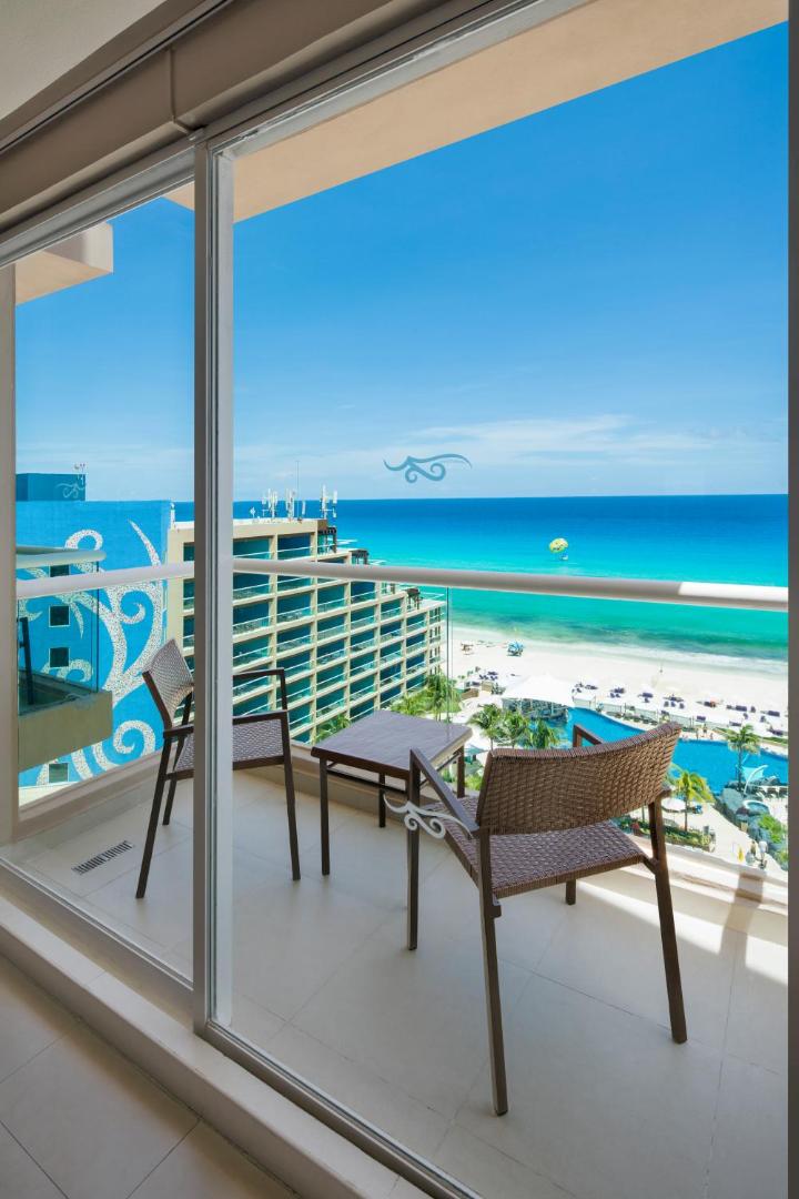 Skats no Hard Rock Hotel Cancun numura balkona uz tirkīzzilo jūru, pludmali un āra baseinu kompleksu Kankunā