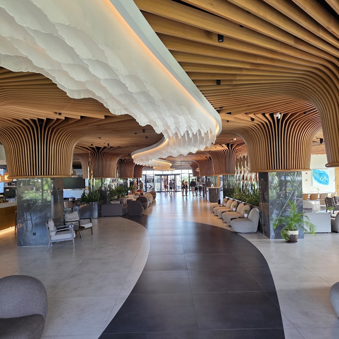 Jacaranda Luxury Resort modernā lobby zona ar unikālu koka siju griestu dizainu, atpūtas krēsliem un plašu gaiteni