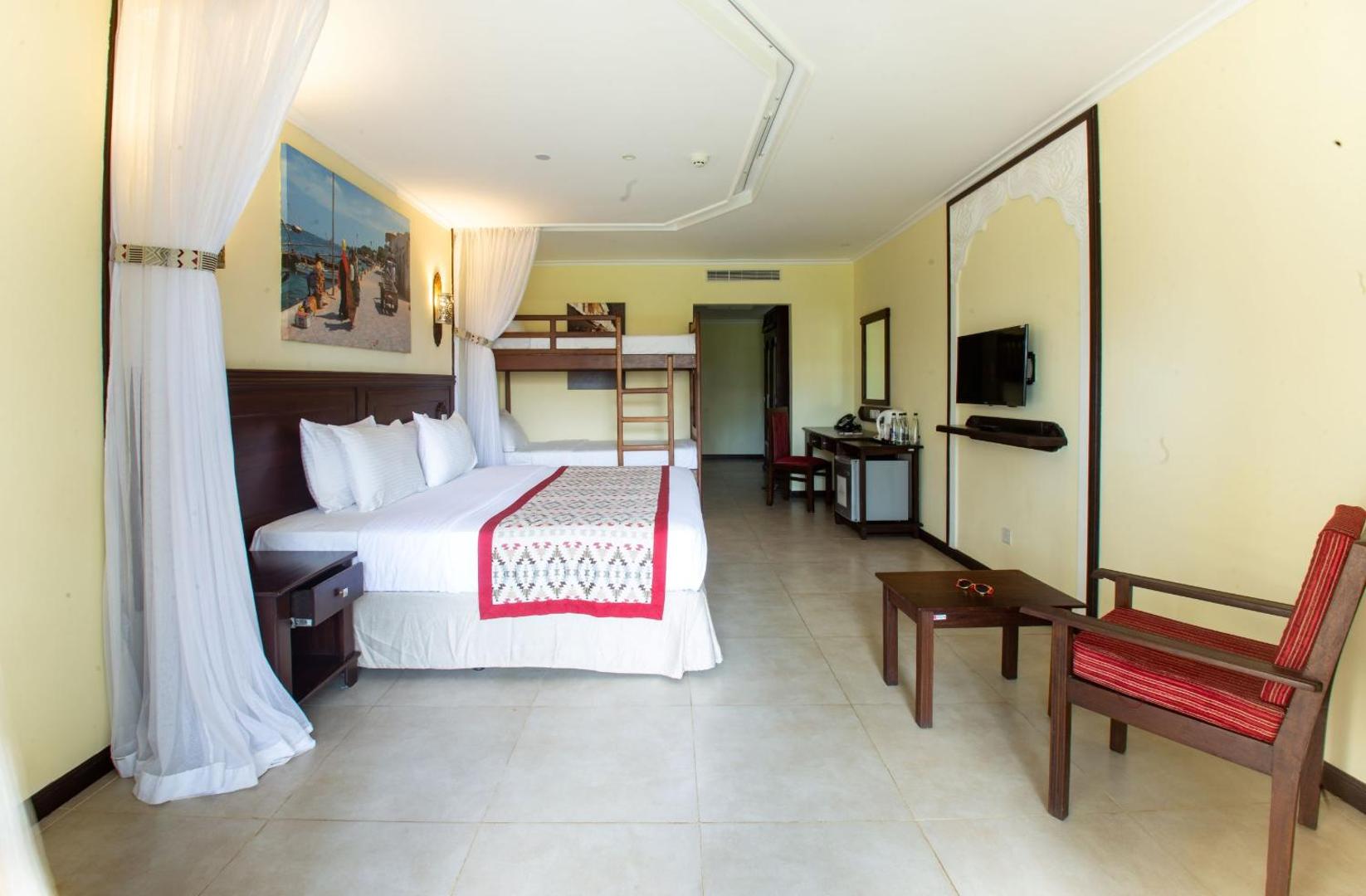 PrideInn Paradise Beach Resort & Spa Mombasa ģimenes numurs ar divguļamo gultu un divstāvu gultu bērniem, gaišs interjers ar koka mēbelēm