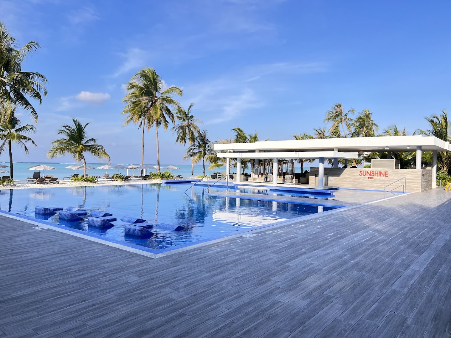 Plašs Hotel Riu Atoll baseina komplekss Sunshine pool ar koka terasi, palmām un atpūtas zonu Maldīvijā