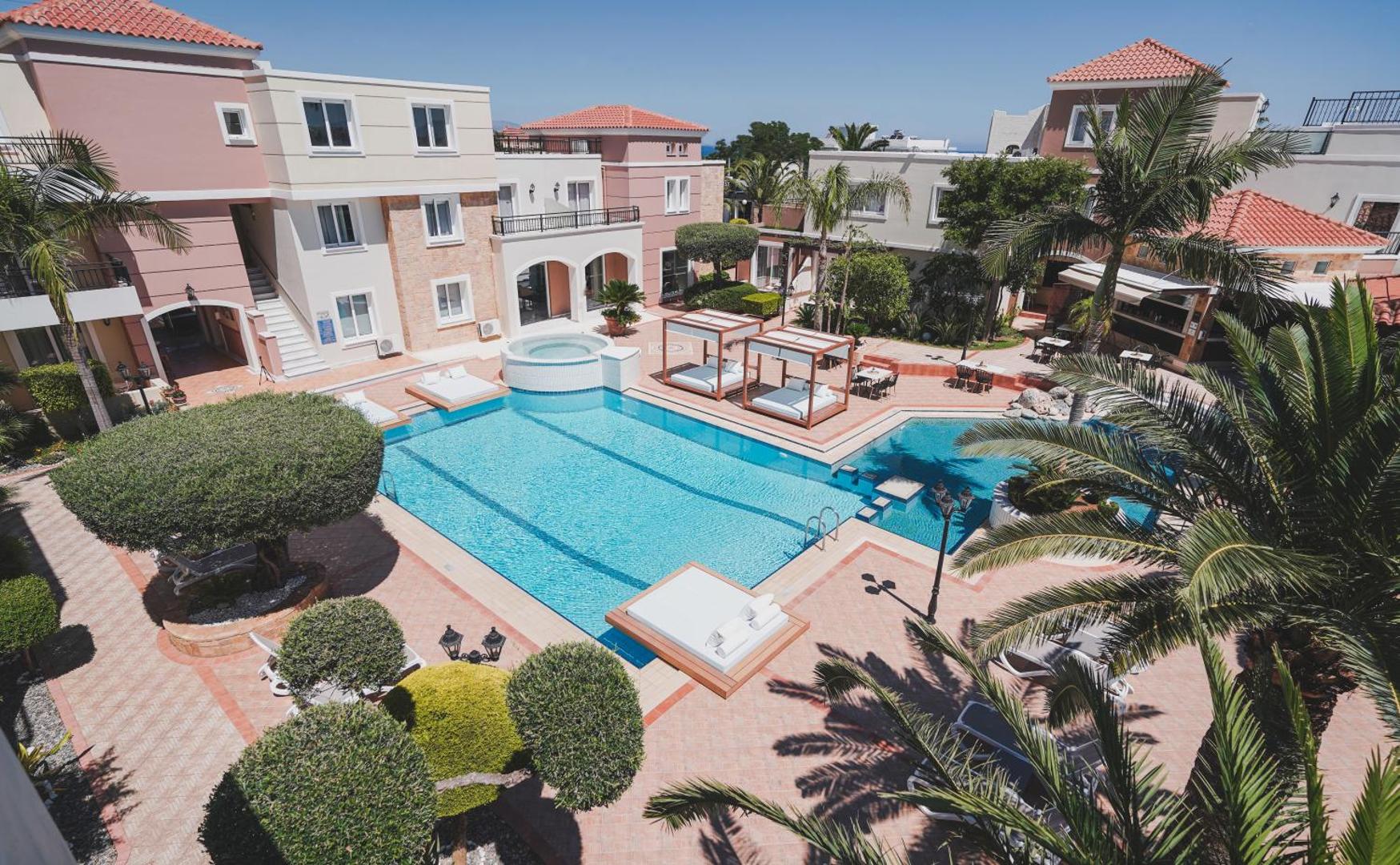 Zeus Hotels The Village Resort & Waterpark centrālais baseins Hersonisā, Krētā — skats no augšas uz atpūtas zonu ar palmām un saulessargiem