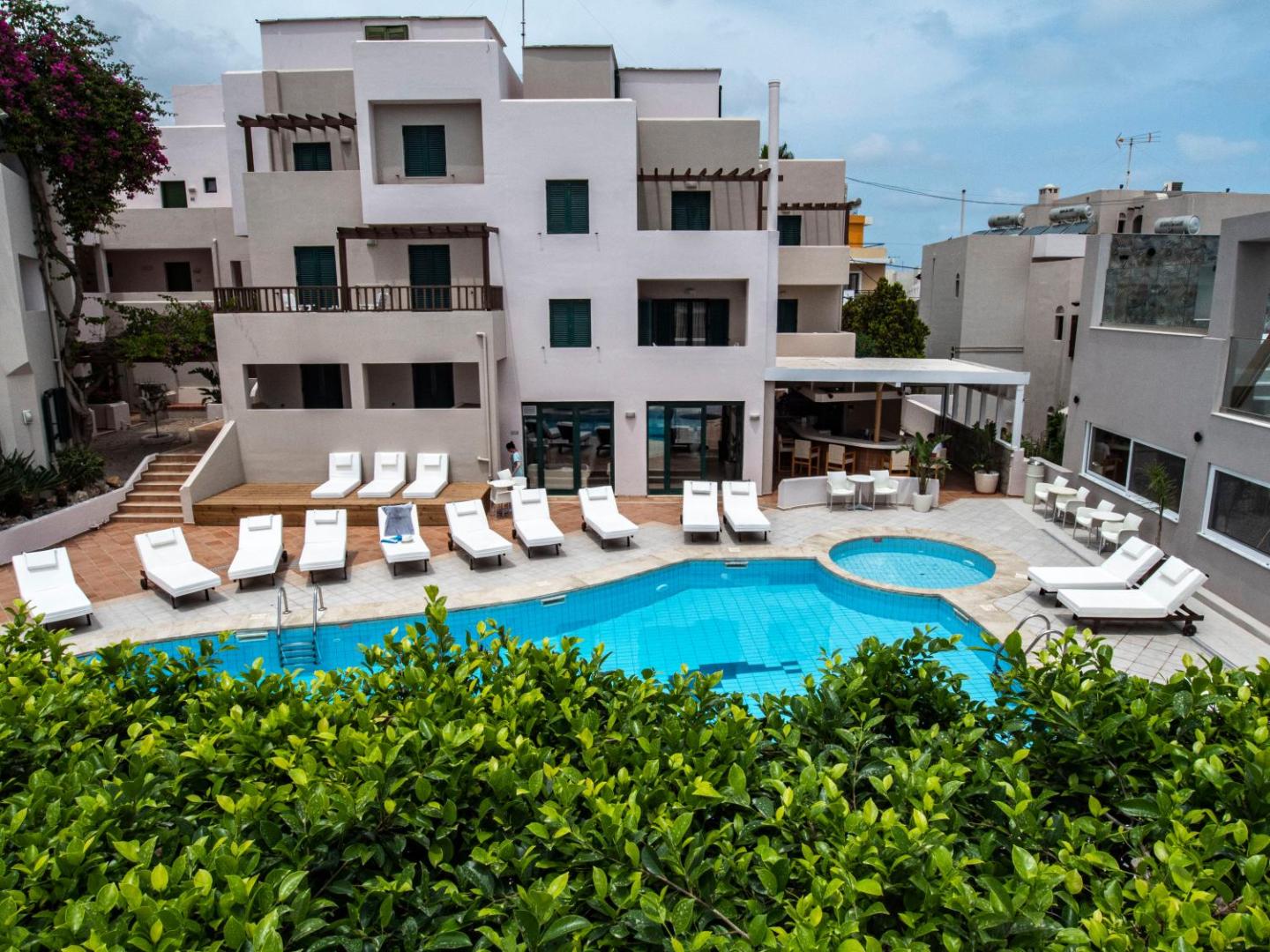 Porto Greco Village viesnīcas ēka ar balkoniem, āra baseinu, bērnu baseinu un sauļošanās zonu Hersonisas kūrortā