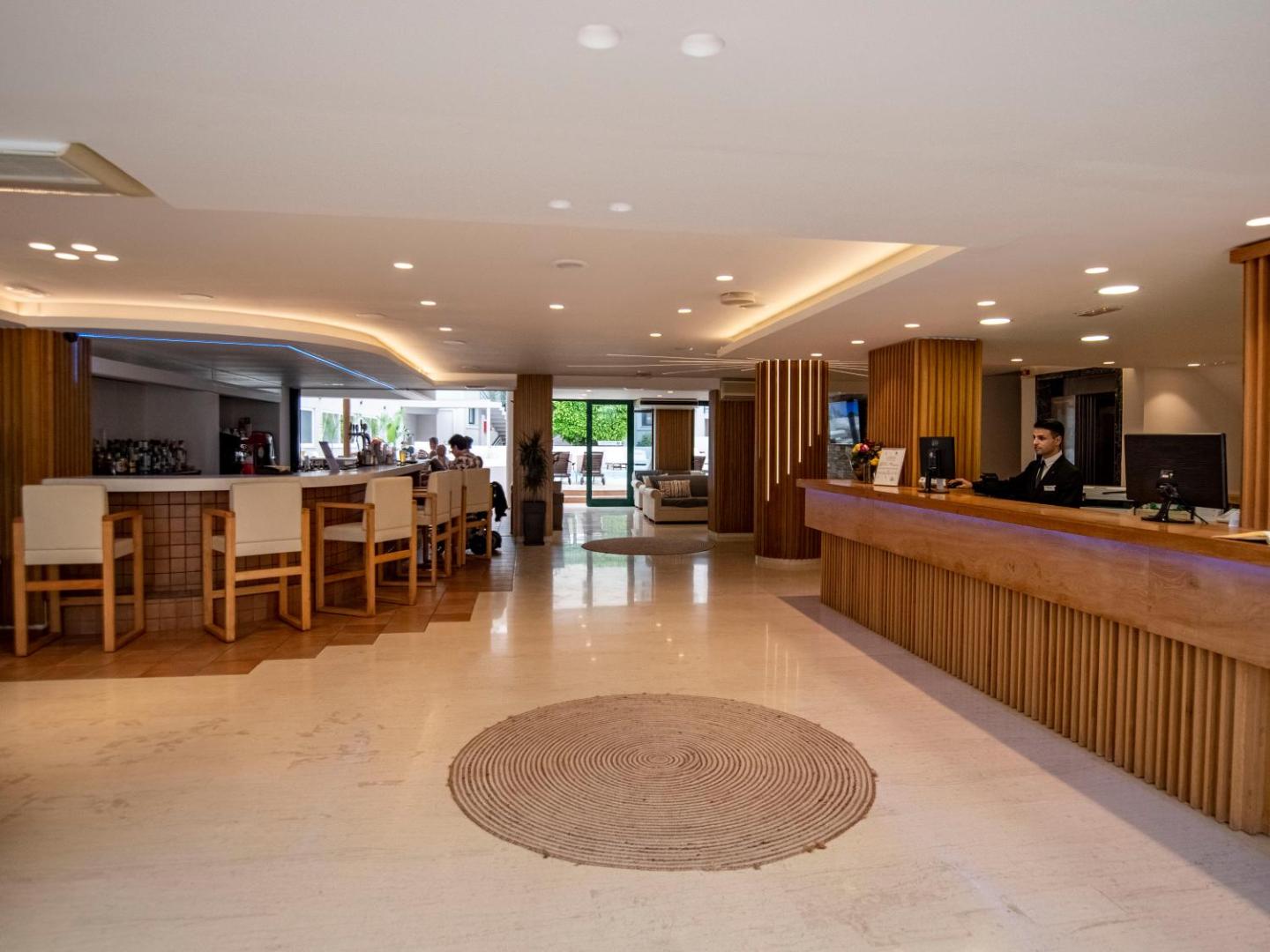 Porto Greco Village recepcijas lete un vestibila bārs ar modernu koka apdari un plašu, gaišu interjeru Krētas kūrortā
