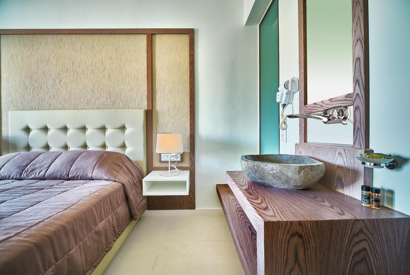 Eva Bay Hotel numura interjers ar akmens izlietni un modernu dizainu — gaišas mēbeles un eleganti koka akcenti