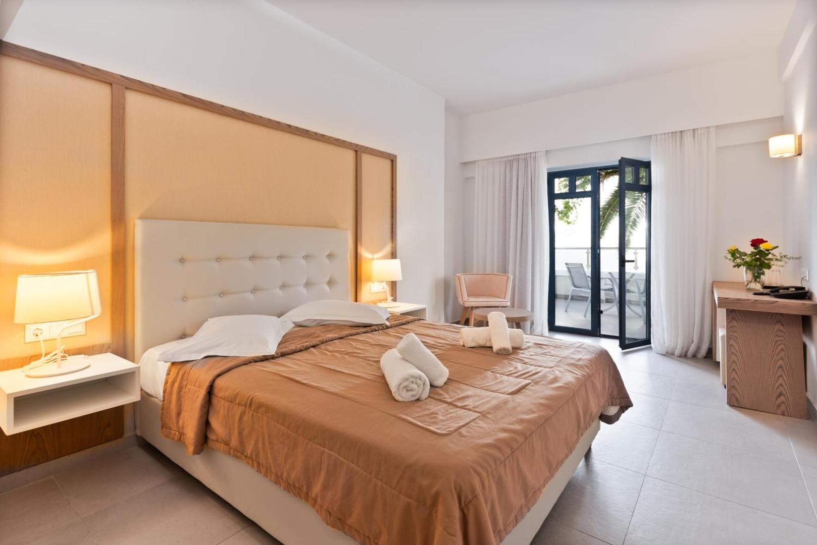 Eva Bay Hotel gaišs divvietīgs numurs ar balkonu, koka apdari un siltu apgaismojumu Retimno reģionā, Krētā