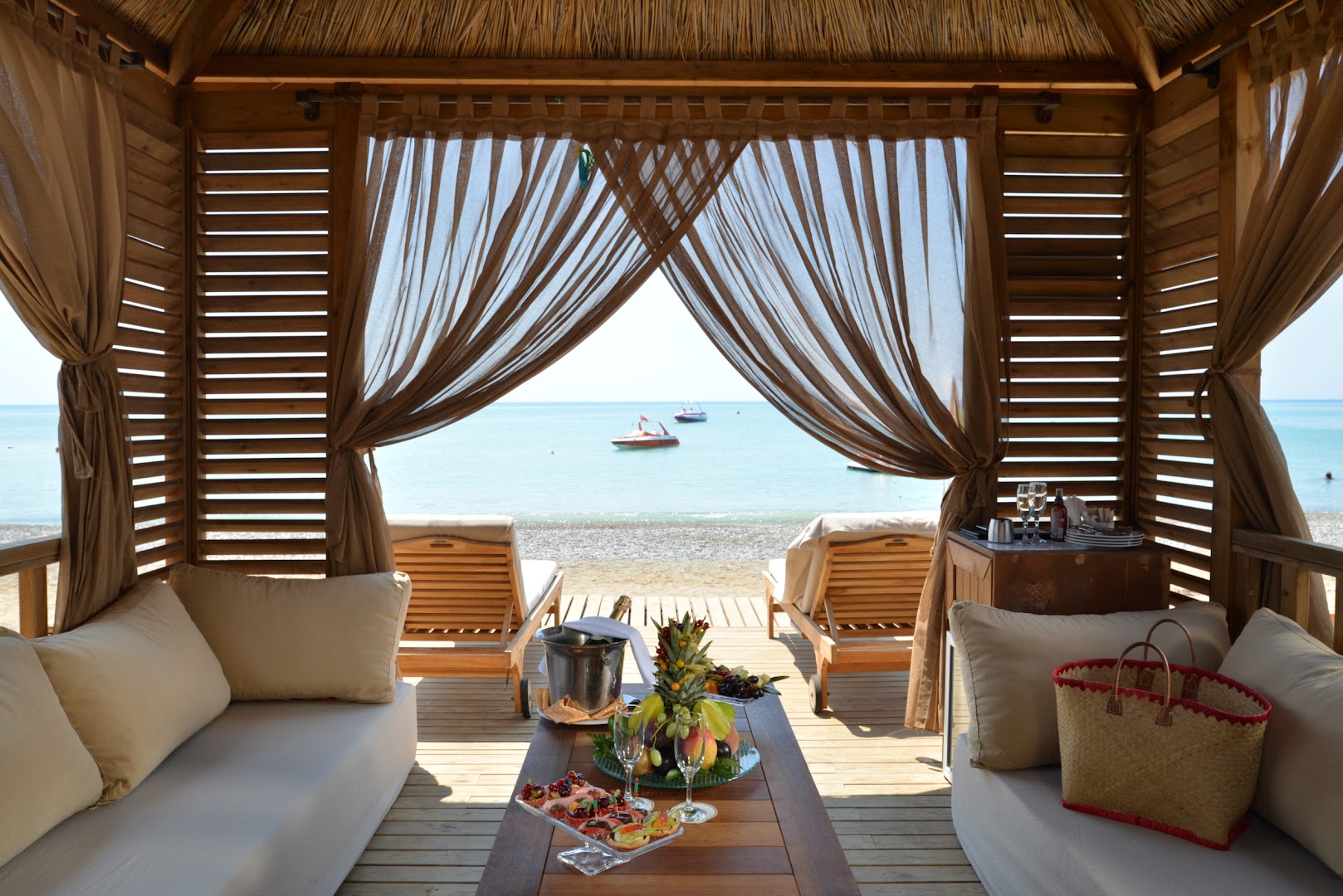 Privāts koka bungalo Dobedan Exclusive Hotel & Spa pludmalē ar mīkstiem dīvāniem, augļu plati un skatu uz Vidusjūru