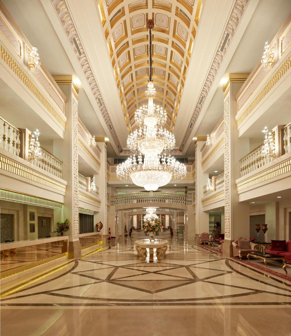 Dobedan Exclusive Hotel & Spa greznais lobby ar augstiem griestiem, milzīgu kristāla lustru un marmora grīdām