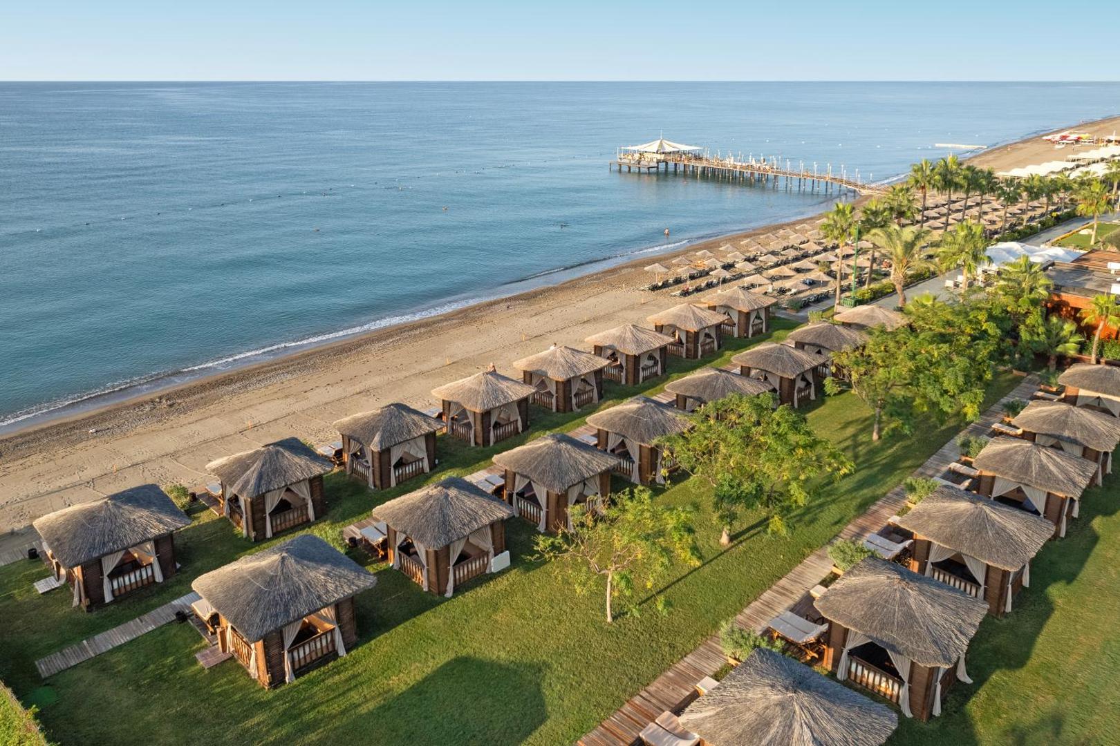 Dobedan Exclusive Hotel & Spa privātā pludmale Belekā ar koka bungalo atpūtas zonu zālienā un skatu uz Vidusjūru