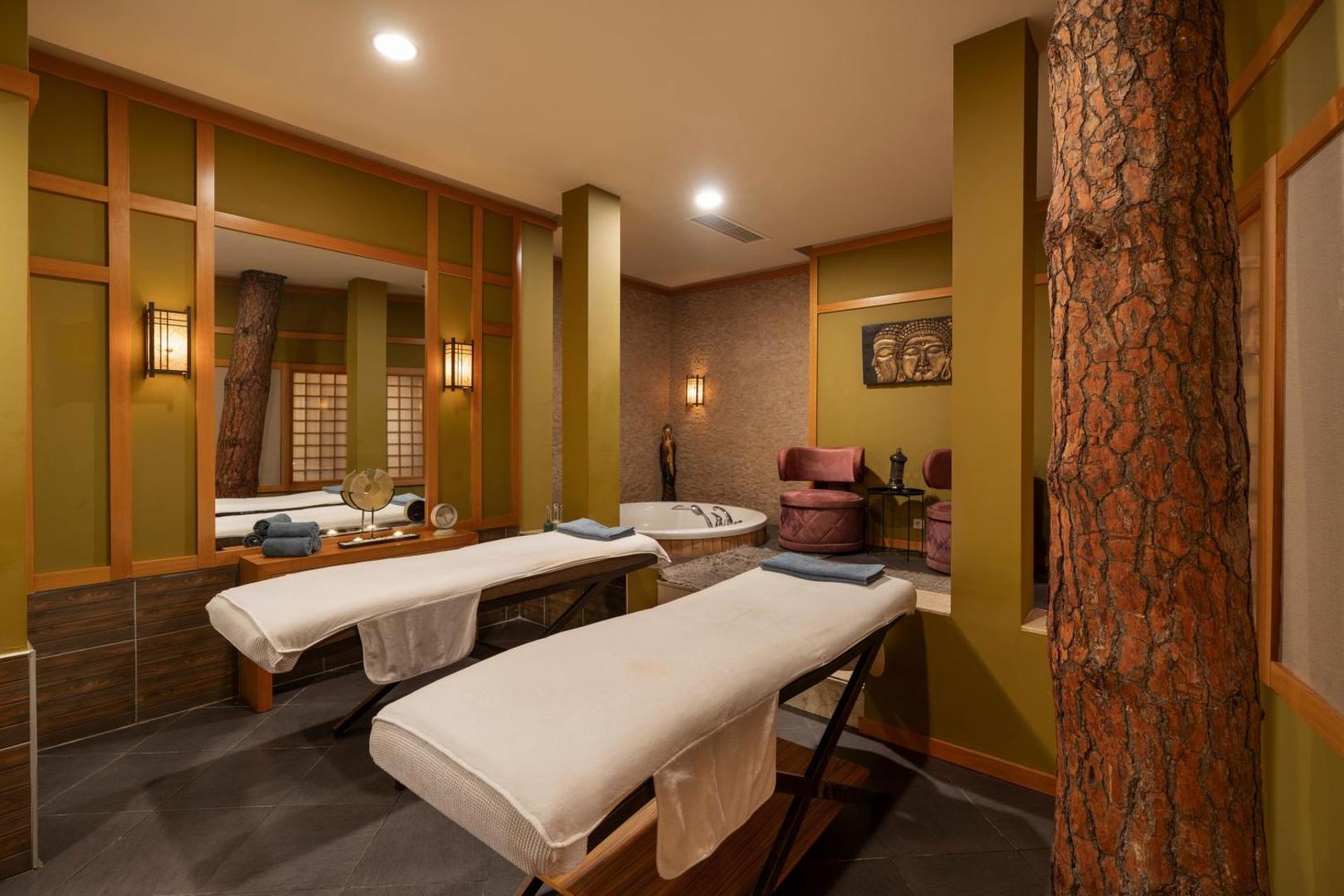 Limak Atlantis De Luxe Hotel & Resort masāžas telpa ar divām kušetēm, džakuzi un austrumnieciskiem dizaina elementiem spa zonā.