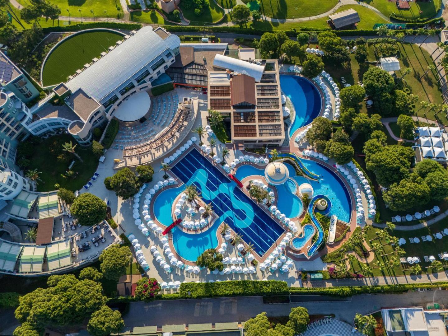 Limak Atlantis De Luxe Hotel & Resort teritorijas skats no putna lidojuma Belekā — plaši baseini, atpūtas zonas un zaļojoši dārzi