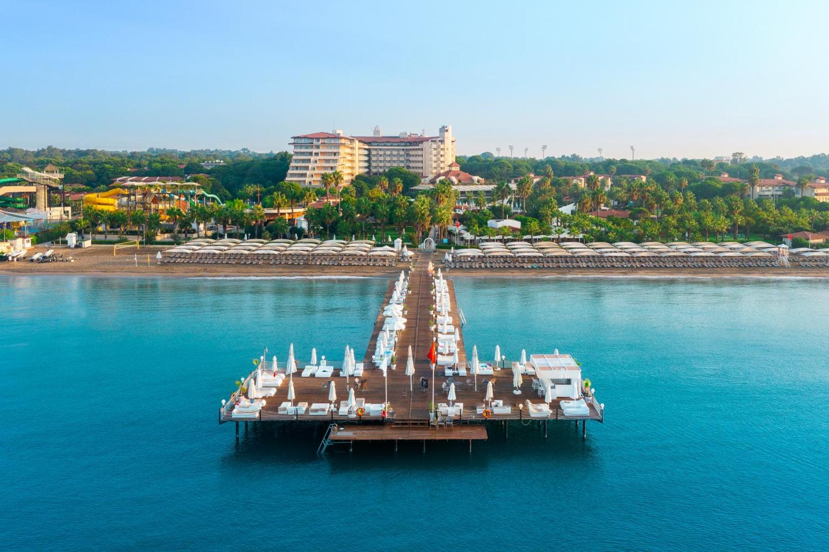 Bellis Deluxe Hotel privātā piestātne un pludmale Belekā — skats no jūras uz kūrorta ēkām un akvaparku