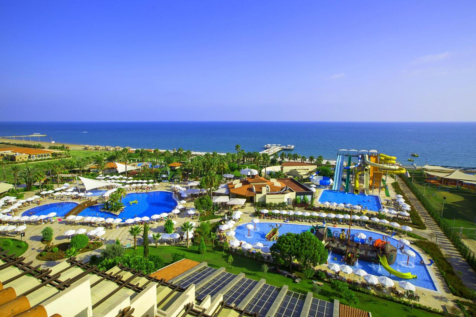 Bellis Deluxe Hotel akvaparks un bērnu baseini ar slidkalniņiem — skats uz jūru un plašo atpūtas zonu ar saulessargiem