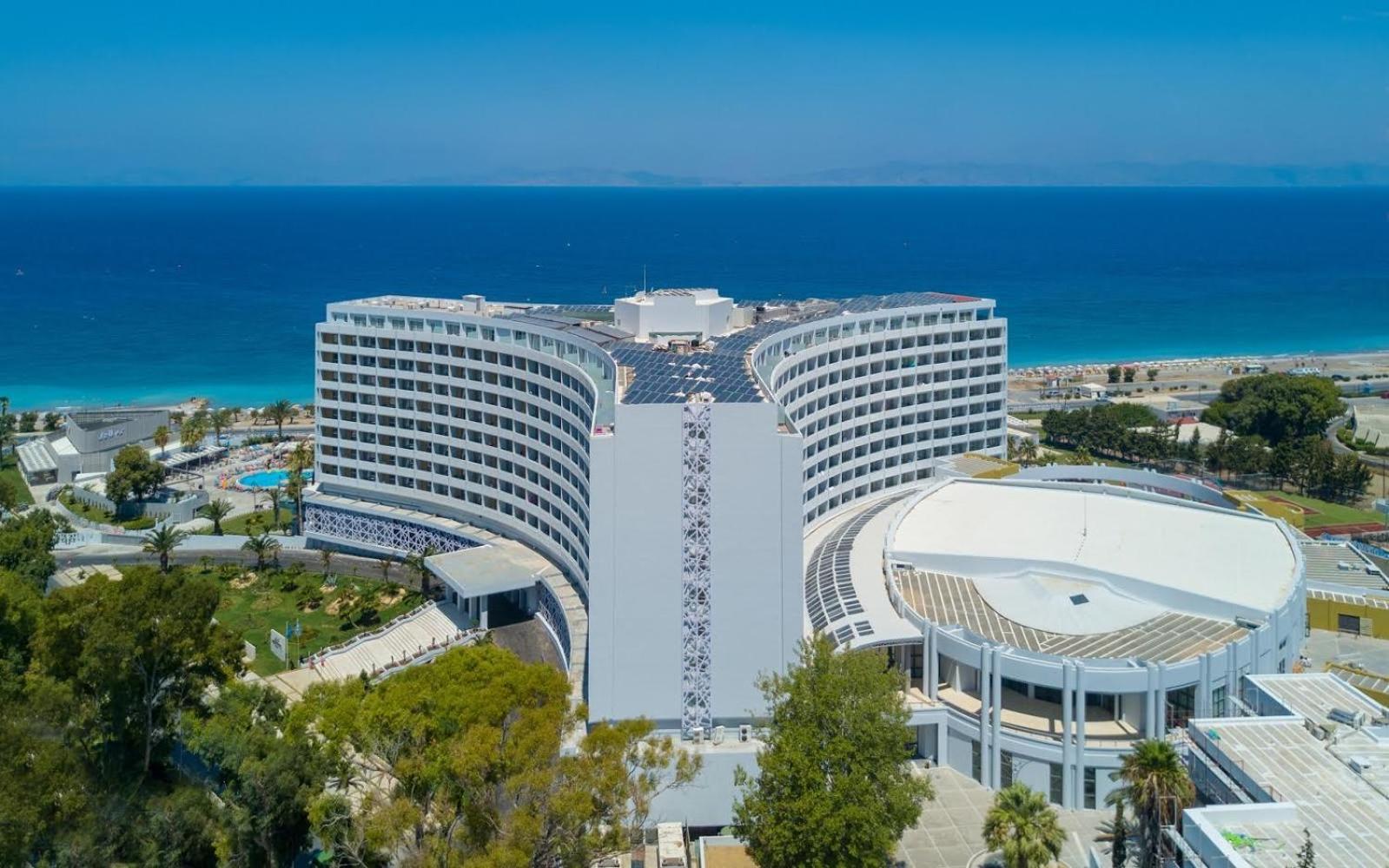 Akti Imperial Deluxe Resort & Spa skats no augšas uz viesnīcas kompleksu, saules paneļiem uz jumta un jūras horizontu