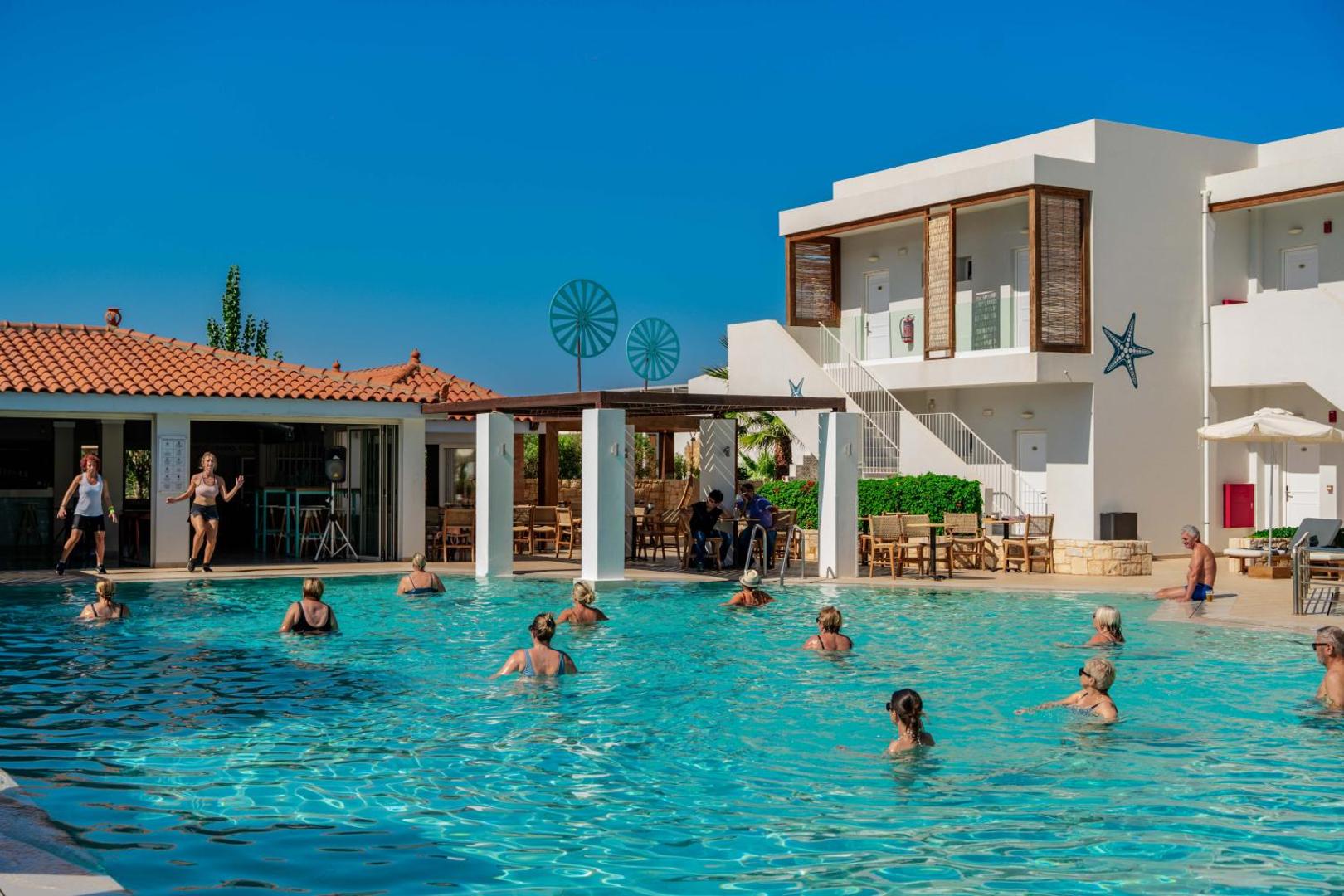 Aelius Hotel and Spa lielais āra baseins ar ūdens aerobikas nodarbību, saulessargiem un viesnīcas ēkām Gūvēs