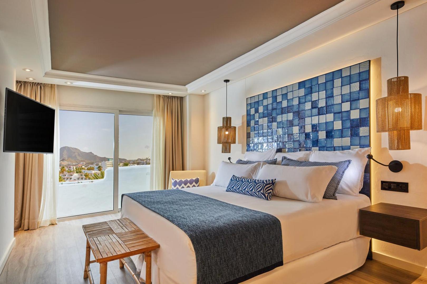 Dreams Jardin Tropical Resort & Spa moderns numurs ar zilu flīžu dekoru, plašu gultu un skatu uz kalniem Tenerifē