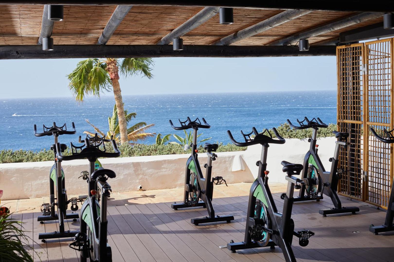 Dreams Jardin Tropical Resort & Spa velotrenažieri uz terases ar skatu uz Atlantijas okeānu Tenerifē — aktīvā atpūta piekrastē